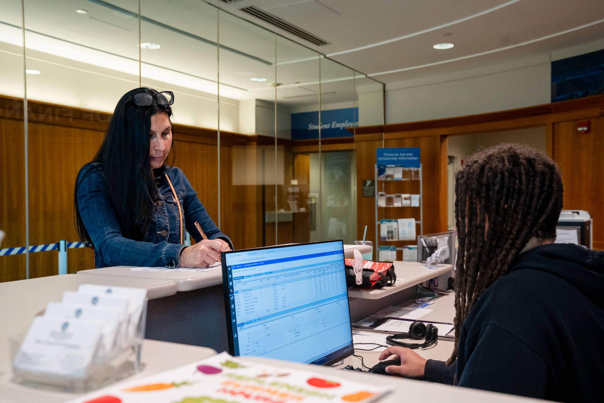 Graduate student worker, Quinton Randall, assists Felecia Militello with paperwork in the Office of Financial Aid and Scholarships.Photo releases on file.